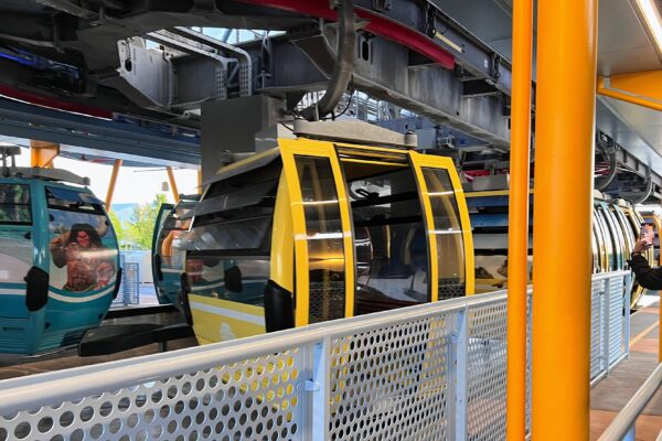 Yellow Disney Skyliner gondolas at a station, ready for a bar crawl.