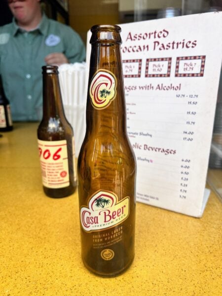 Casa Beer, a Moroccan lager from EPCOT, with Moroccan pastries menu in background.