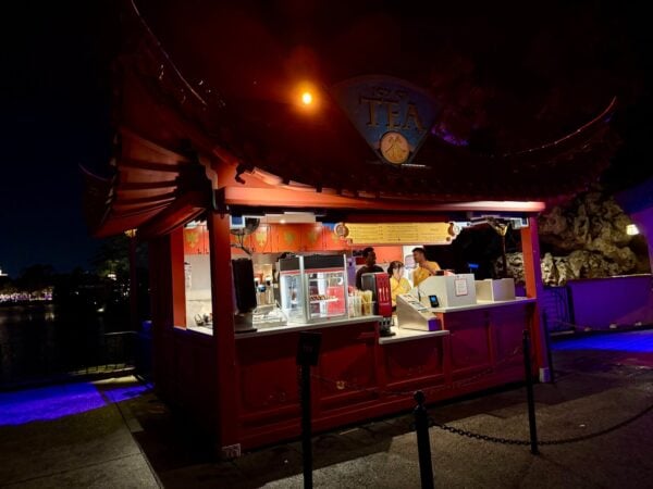 The Joy of Tea stand at EPCOT's China pavilion at night, with an empty queue and the drink menu board above the window